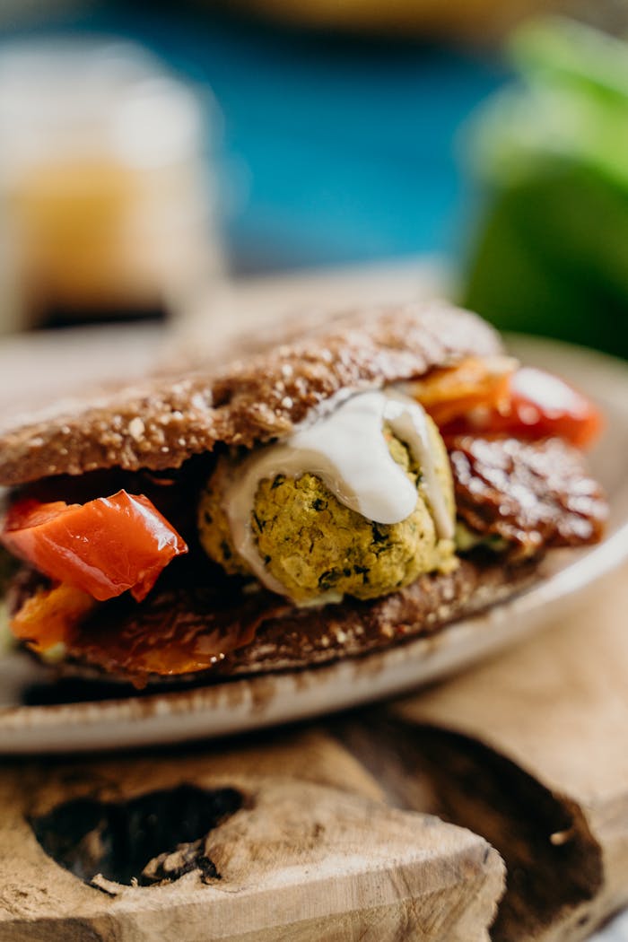 Delicious vegan falafel sandwich with fresh tomatoes and sauce.